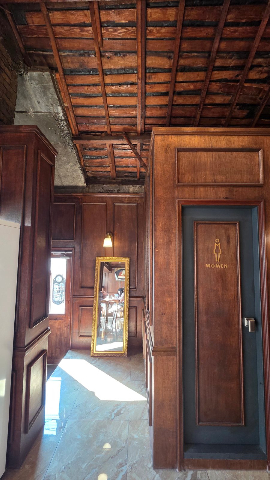 Hallway with wooden walls and a mirror